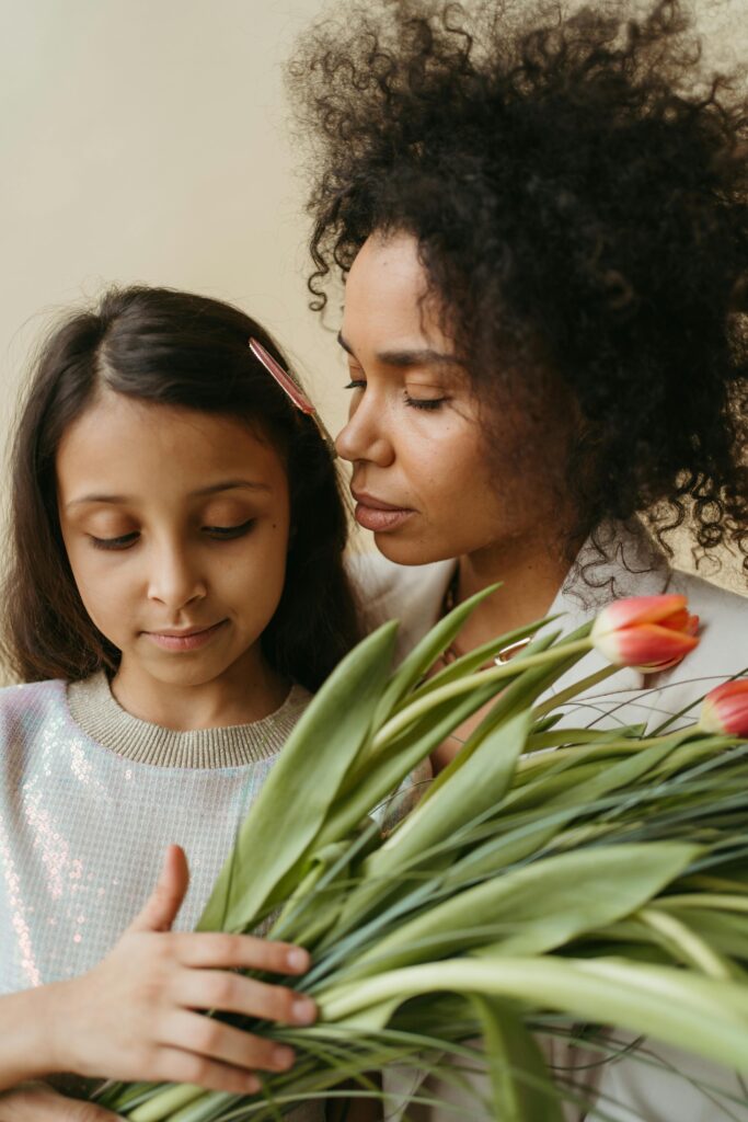 A tender scene of a mother with her daughter holding tulips, perfect for Mother's Day themes.